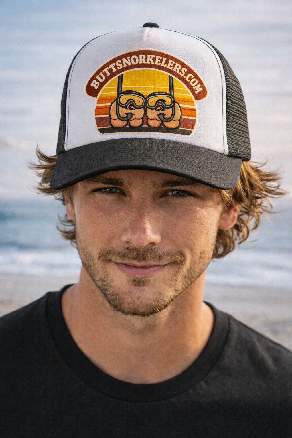 ButtSnorkelers trucker hat — man at beach wearing white and black trucker hat with embroidered logo patch